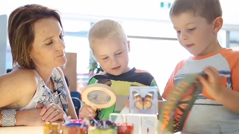 A teacher works with two young learners to review their understanding of the life cycle of butterflies.